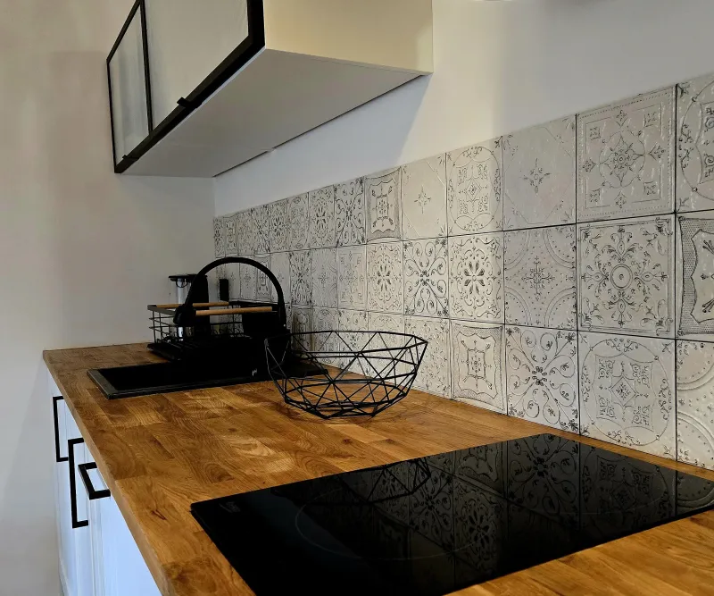 Wyposażony aneks kuchenny w lodówkę, płytę grzewczą, czajnik, naczynia i garnki